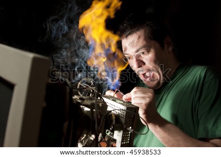 Man repairing computer on fire