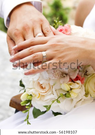 stock photo Hands and rings on wedding bouquet