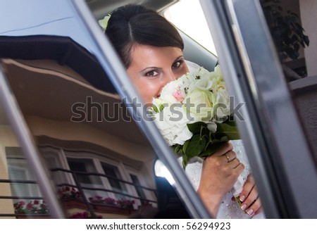 Happy bride inside car with her house reflecting in the window