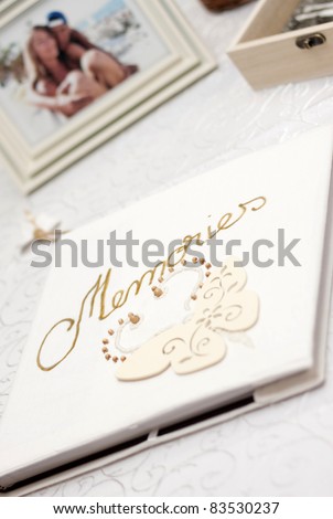 White photo album with Memories written with golden font and blurred picture of couple in the background