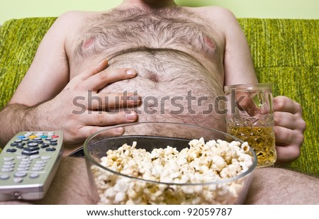 Fat man with glass of beer and popcorn