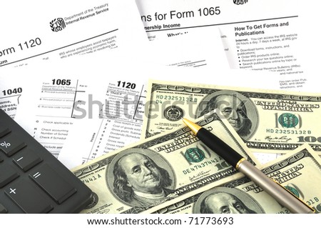 Tax Season. The concept image with a calculator, money and tax return forms.