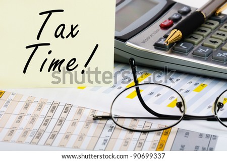Tax forms with pen, calculator, glass and sticker.