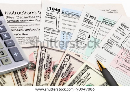 Tax forms 1040 with pen, calculator and money.