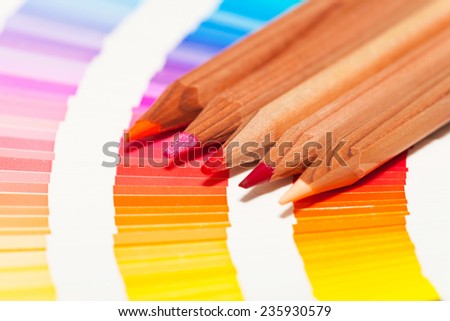 red and pink colored pencils and color chart of all colors