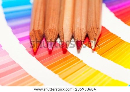red and pink colored pencils and color chart of all colors