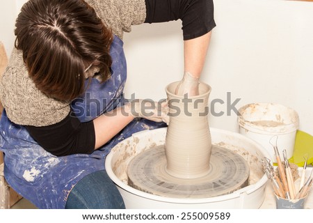 Female Potter creating a earthen jar on a Potter\'s wheel