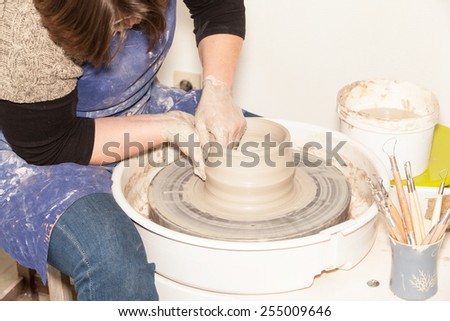 Female Potter creating a earthen jar on a Potter\'s wheel