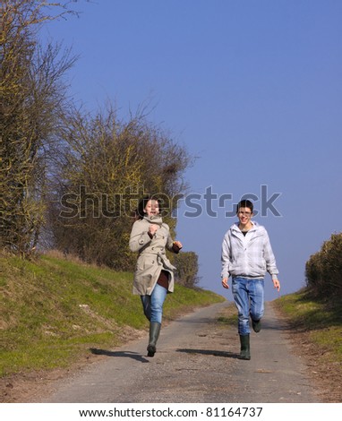 Couple of young people walking in the campaign in spring
