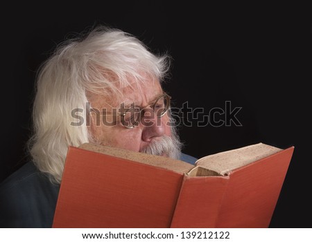 Old man reading a book, scientist and teacher with beard and glasses