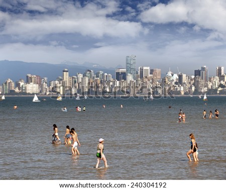 VANCOUVER - AUGUST 15, 2010: Shallow and warm waters and beaches of English Bay by Kitsilano are popular place for locals and visitors. Skyline of the city with new Shangri La building.