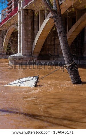 Sinking boat due to the flood in Pisuerga river.