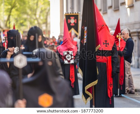 VALLADOLID, SPAIN - APRIL 17, 2014: Red and black nazarenos in the religious processions during Holy Week on Good Thursday, on April 17, 2014 in Valladolid, Spain.