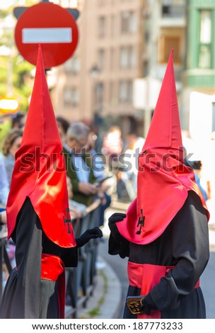 VALLADOLID, SPAIN - APRIL 17, 2014: Two red and black nazarenos in the religious processions during Holy Week on Good Thursday, on April 17, 2014 in Valladolid, Spain.