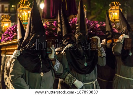 VALLADOLID, SPAIN -Â?Â? APRIL 17, 2014: Nazarenos carrying a sculpture in the religious processions during Holy Week on Good Thursday Night, on April 17, 2014 in Valladolid, Spain.