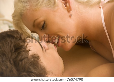 Young lovers in bed kissing