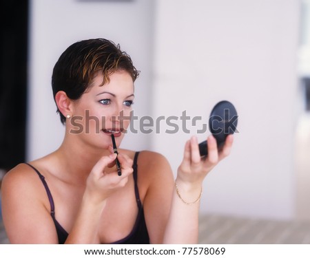 Stunning woman applies liner to her lips