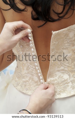 Brides dress being zipped up