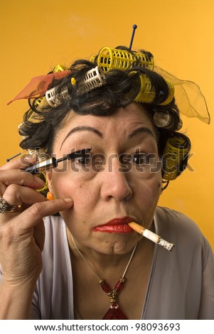 Old woman smoking and applying make up