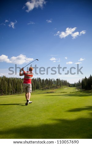 Male golfer shooting a golf ball