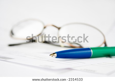 Pen and eyeglasses on top of financial statements