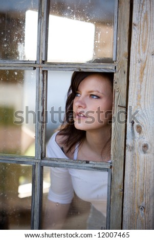 Woman looking outside from broken window