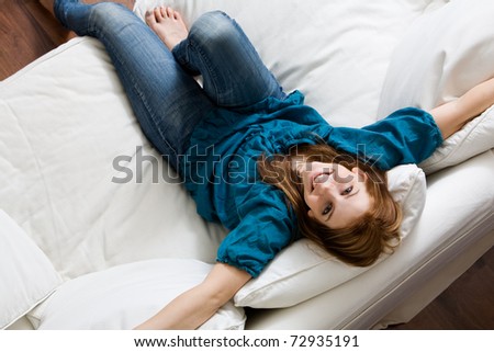 Young attractive woman relaxing on white sofa