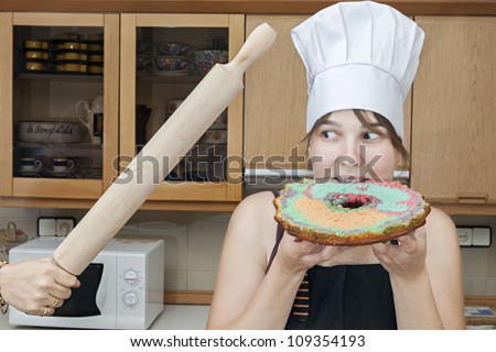 cook eating a cake while a hand was threatened with a kitchen utensil