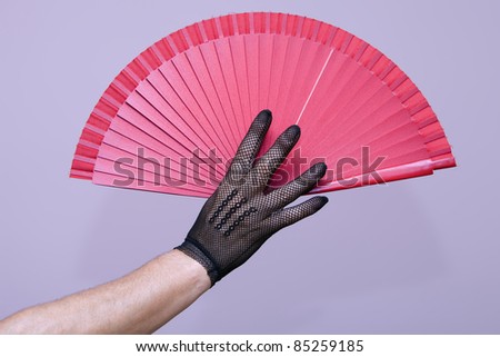 open hand with a glove holding an open fan