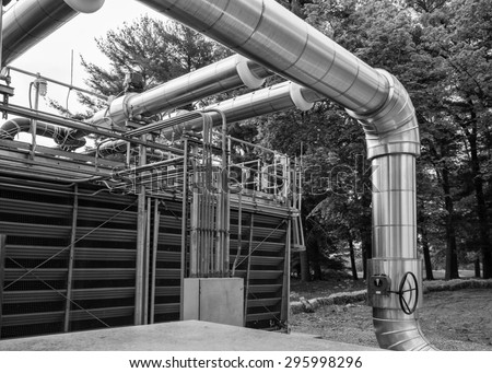 Front of cooling tower showing piping an valve.  Electrical conduits and mechanical system piping in a cooling tower yard.