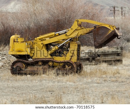 Rusted bucket loader decaying road side in the western US.