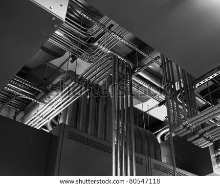 Electrical conduits run along a ceiling in a switchgear room.