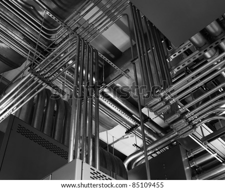 Odd angles of electrical conduits captured in black and white.  Taken in an industrial building.