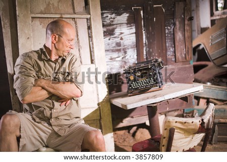 Frustrated Man looking at Vintage typewriter.