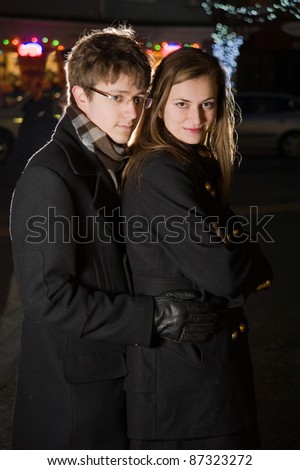 Beautiful young couple shopping in city night. Shallow DOF