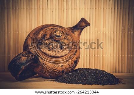 old clay teapot and black leaf tea.