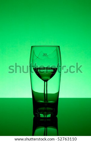 broken wine glass behind beer glass - alcoholism concept