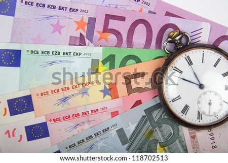 Time and Money concept image.  Close-up of  Euros  with vintage watch.