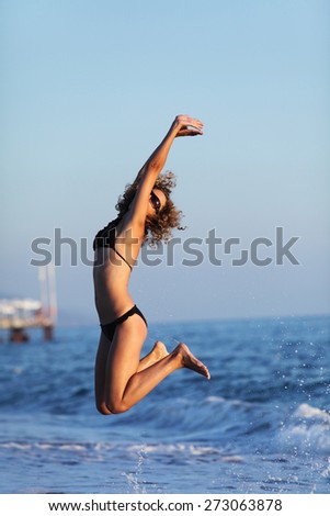 Woman jumping in bikini, on sea water. Relax, vacation