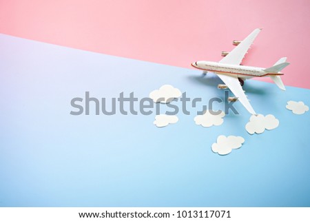 Flat lay design of travel concept with plane and cloud on blue and pink background with copy space.