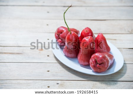Six Rose apples on wooden table