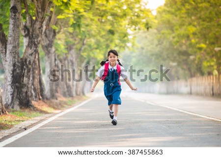 portrait of school kids running on the way in park (focus on the girl)