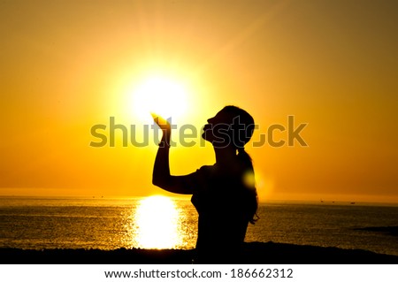 A beautiful girl silhouette kiss  the sun