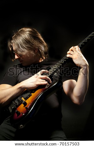 Guitar Man perform a guitar solo with tapping  isolated on black background