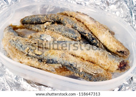 Roasted and breaded vendace fish (european cisco) in plastic food container