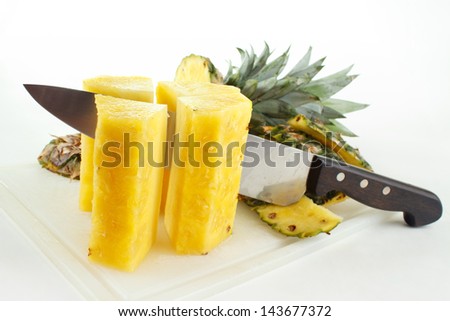 Cutting fresh pineapple on cutting board