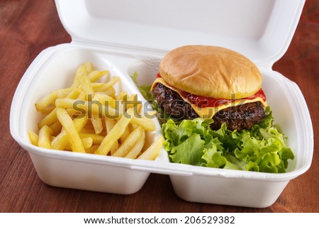 Burger and fries portion in takeout food box
