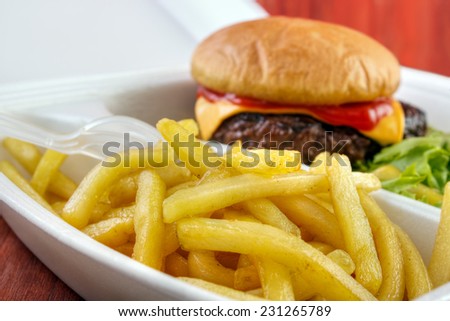 Burger with fries portion from fast food service closeup