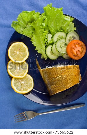 Smoked whitefish with salad on the dish, upper view.