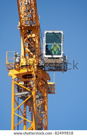 Crane operator sitting in his cabin in construction site